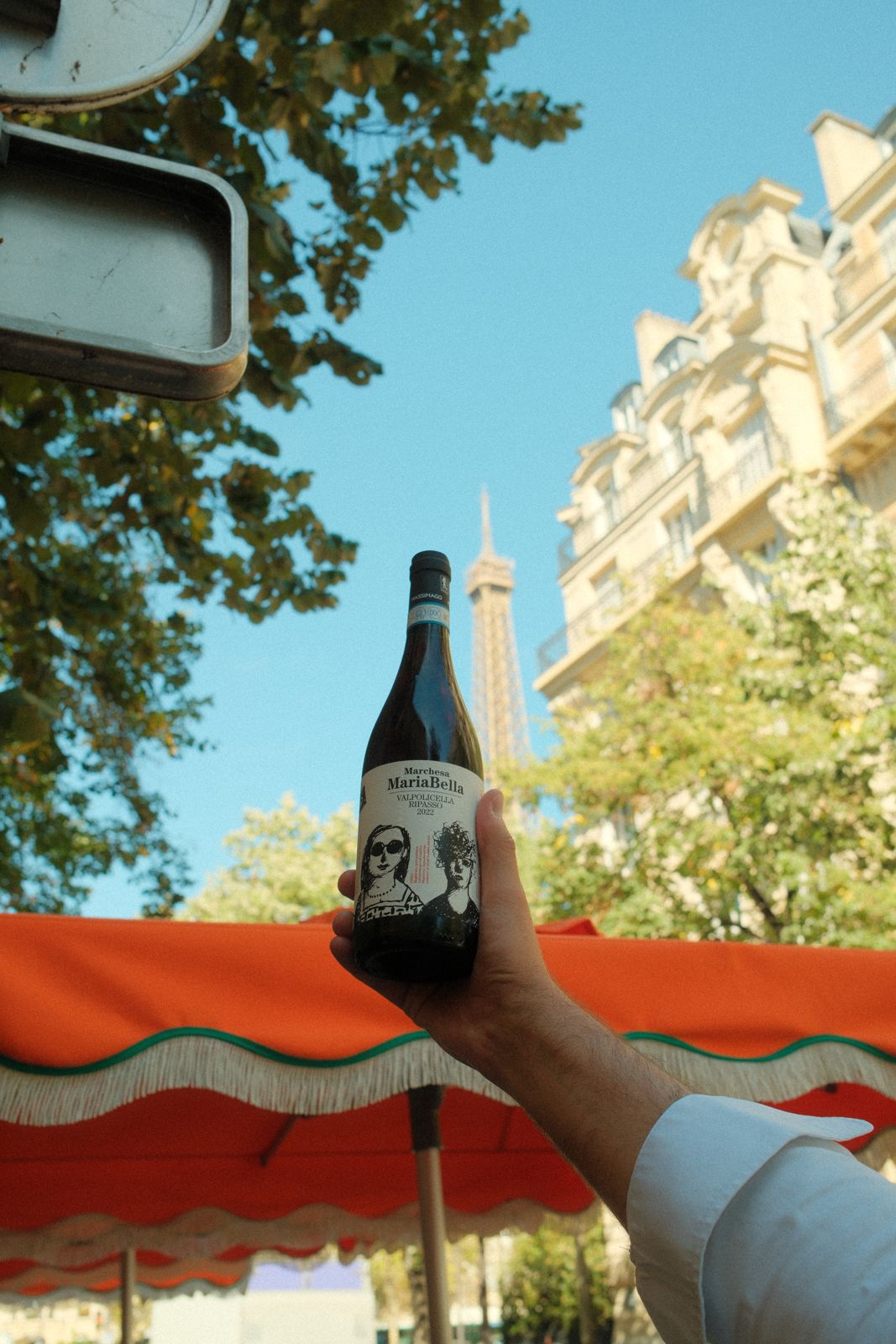 Bouteille de vin levée devant la Tour Eiffel