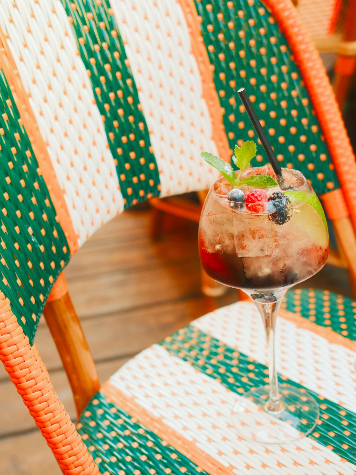 Cocktail aux fruits rouges posé sur une chaise rayée