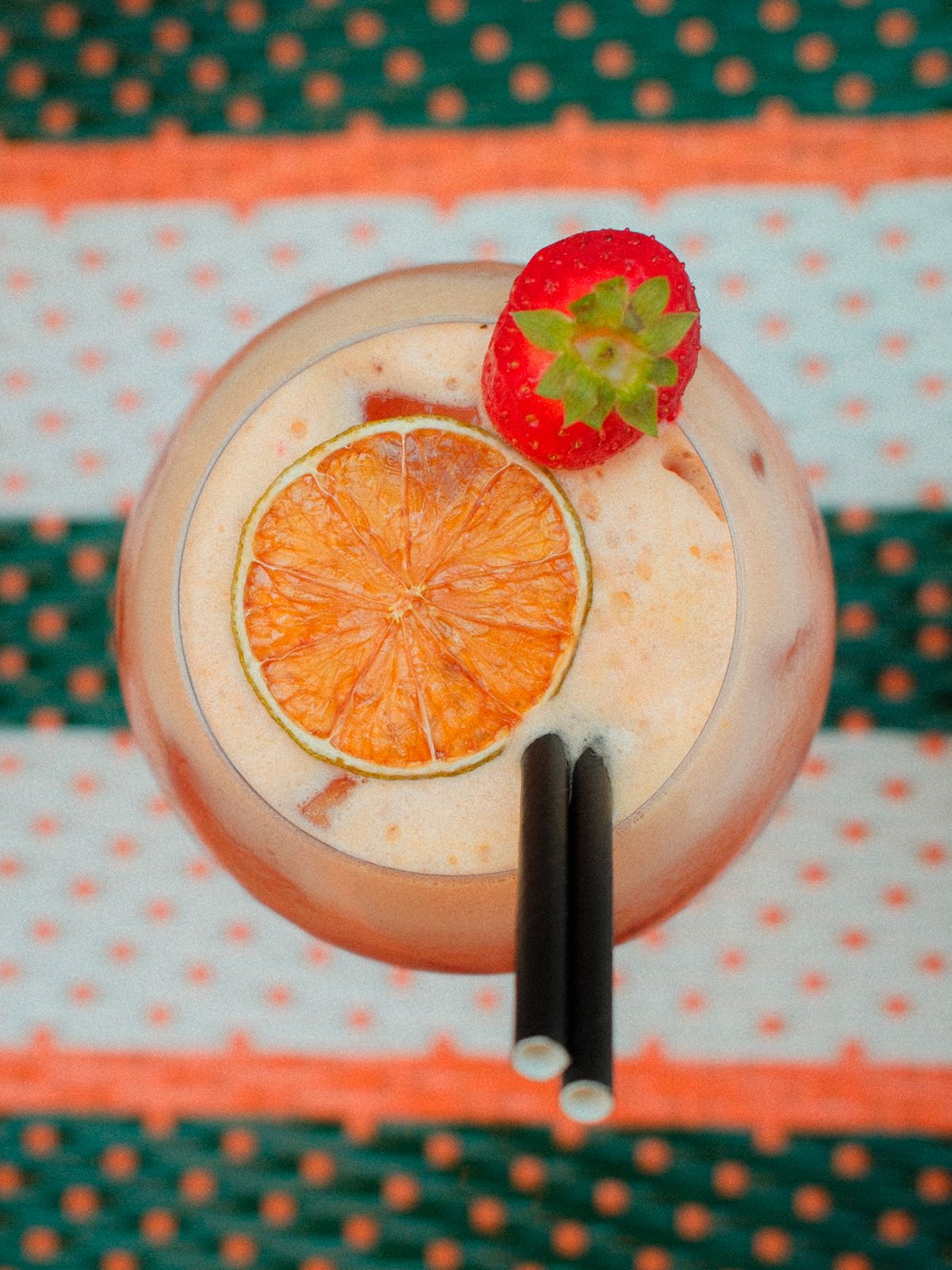 Cocktail à l'orange sur la table rayée
